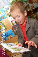 Ребёнок увлеченно рассматривает книжку, снимок из архива детского фотографа